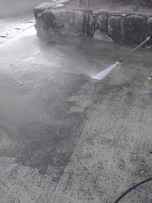 駐車場の土間コンクリートを高圧洗浄している写真